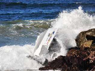 A runabout that capsized on the Evans River bar on Tuesday, July 13, is smashed by waves against the breakwall. . Picture: Dan Perrier