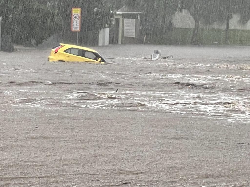 The bridge over Enoggera Ck, Ashgrove goes under and takes a car with it. Picture: Des Houghton.