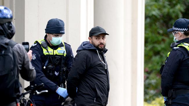 Police arrest a group of people gathered at the Janet Lady Clarke Rotunda in the Queen Victoria Gardens in Melbourne as Stage 4 restrictions continue. Picture: Andrew Henshaw