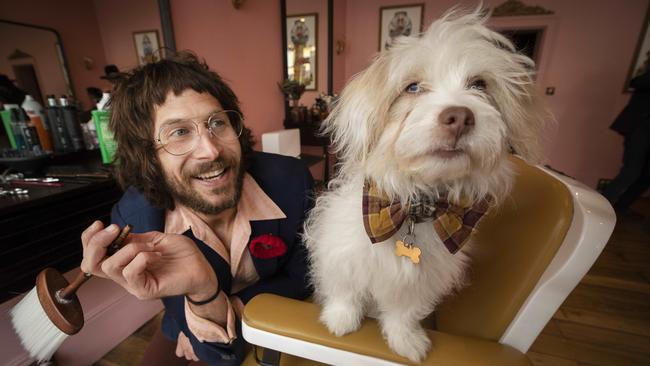 Paradise Lost Barbershop owner Lee Power with a furry friend. Picture: Chris Kidd