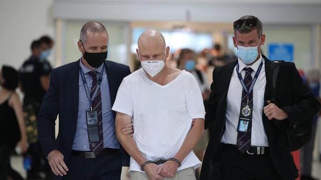 Fugitive and ex-snooker champion Michael Tillman is led through Gold Coast airport to a waiting police car after being extradited from Sydney. Picture Glenn Hampson