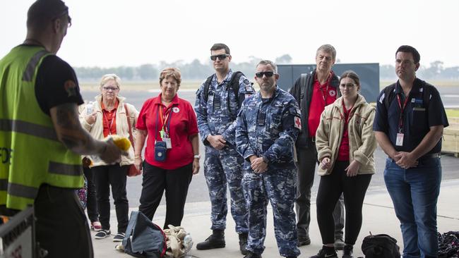 Royal Australian Air Force Sargent Josh Baker briefs Royal Australian Air Force and Red Cross personnel on flying conditions before they fly out of RAAF Base East Sale during a bushfire assistance operation.