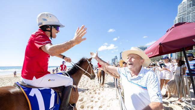 Nacho Figueras high fives Magic Millions co-owner Gerry Harvey at the Magic Millions Beach Run and Barrier Draw. Picture: Luke Marsden.