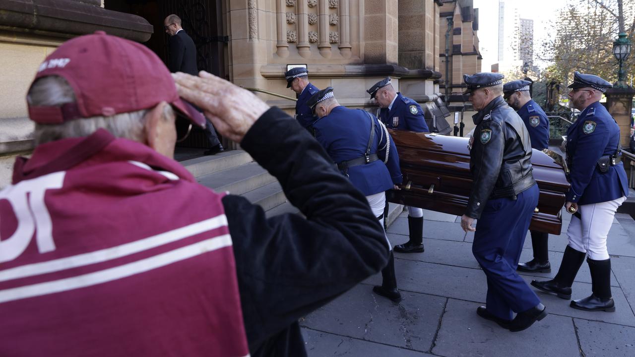 SYDNEY, AUSTRALIA - JUNE 04: Russell, a Manly fan of 61 years, salutes the the coffin carrying Robert Fulton at St.Mary's Cathedral before the State Funeral in his honour on June 04, 2021 in Sydney, Australia. Robert Fulton is considered a rugby league 'Immortal' for his achievements in the game as a player, coach and commentator. (Photo by Pool/Getty Images)