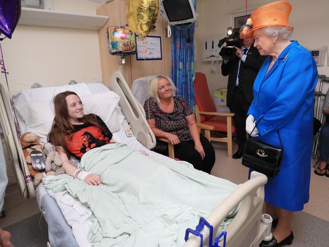 Britain's Queen Elizabeth II speaks to Millie Robson, 15, from Co Durham, who was injured in the Manchester Arena terror attack, and her mother Marie, center, during a visit to the Royal Manchester Children's Hospital. Picture: AFP / Peter Byrne
