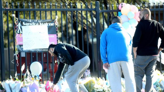 Members of the school community leave tributes at the gate. Picture: John Grainger