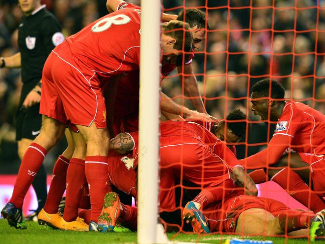 Liverpool players celebrate after Liverpool's English defender Glen Johnson scores during the English Premier League football match between Liverpool and Stoke City at Anfield in Liverpool, north west England on November 29, 2014. Liverpool won the game 1-0. AFP PHOTO / PAUL ELLIS RESTRICTED TO EDITORIAL USE. No use with unauthorized audio, video, data, fixture lists, club/league logos or “live” services. Online in-match use limited to 45 images, no video emulation. No use in betting, games or single club/league/player publications.