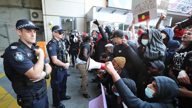 Police officers watch on as activists take part in the Black Lives Matter rally. Picture: Peter Wallis