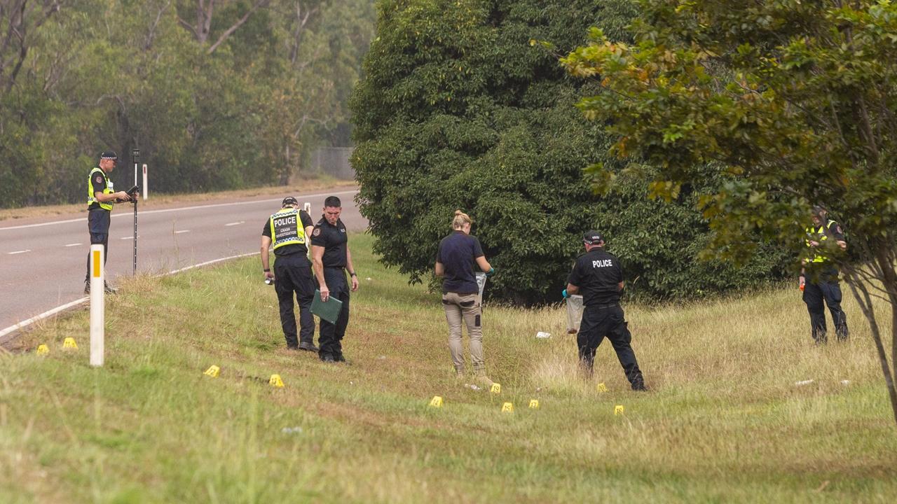 At the crime scene on the Stuart Hwy, near Coolalinga, Investigators walk away with a mysterious object in an evidence bag. Picture: Floss Adams.