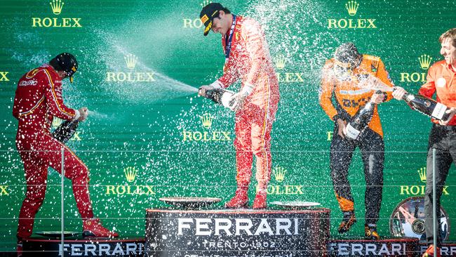 Australian F1 Grand Prix winner Carlos Sainz celebrates on the podium with Charles Leclerc and Lando Norris. Picture: Jake Nowakowski