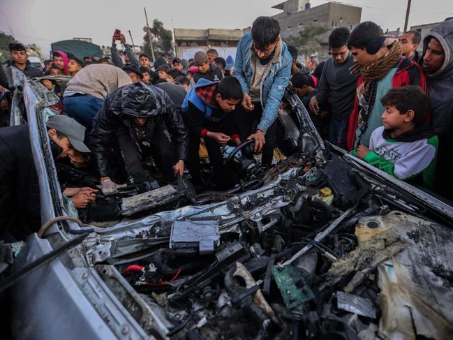 Men and boys inspect a car that was destroyed by Israeli air strikes in Rafah, Gaza. Picture: Getty Images