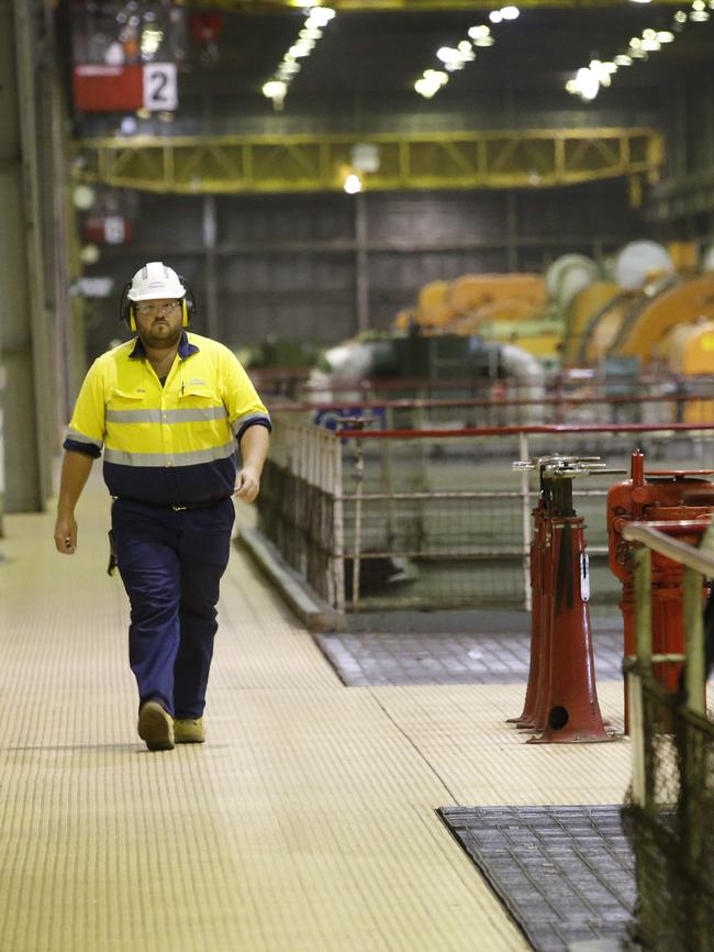 A worker walks past the turbine generator units. Picture: David Caird