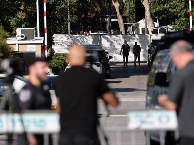 TOPSHOT - Israeli security forces gather behind a barrier across a street leading to Prime Minister Benjamin Netanyahu's residence in Caesarea on October 19, 2024. Netanyahu's office said a drone was launched toward his residence on October 19, after the military reported a drone from Lebanon had "hit a structure" in the central Israeli town. (Photo by Jack GUEZ / AFP)