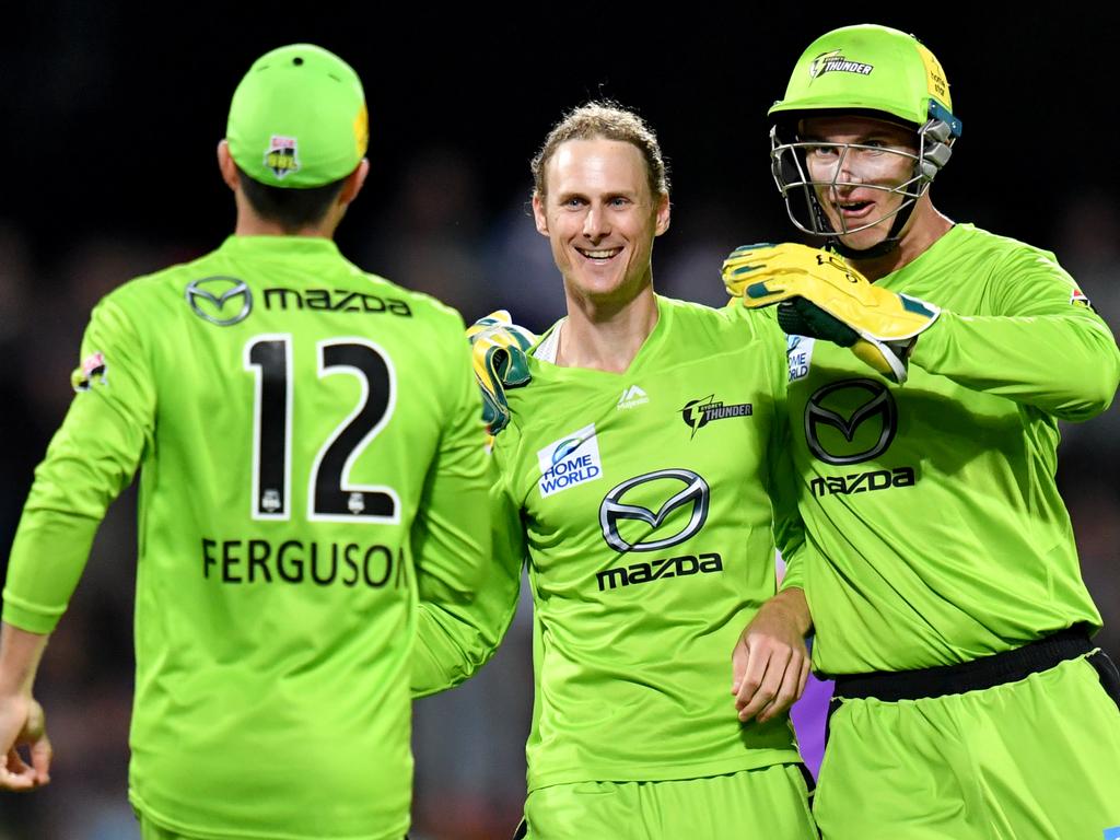 Jono Cook (centre) of the Thunder celebrates with Callum Ferguson (left) and Jay Lenton (right)