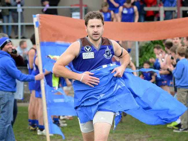 Shaun Payze runs through a banner for his 300th game in 2013.