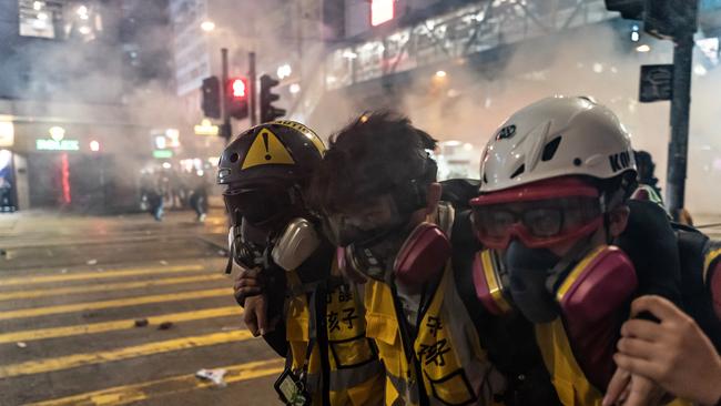 Protest volunteers react after police fired teargas in Wan Chai district.