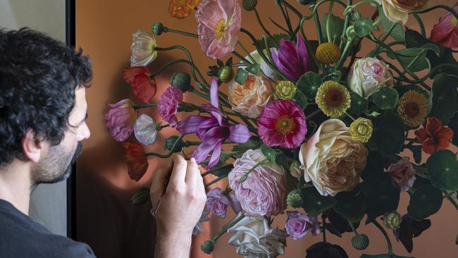 Artist Sebastian Galloway adds the finer details to his floral paintings on copper which form part of his latest exhibition Suspended in Bloom. Picture: Supplied