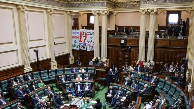 Climate change protesters unfurl banners in the public gallery of Victoria parliament during Question Time. Picture: Ian Currie