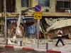An Israeli rescuer walks in front of a damaged shop in Tel Aviv, after it was hit by a rocket fired by Palestinian militants from the Gaza Strip on October 7, 2023. Palestinian militant group Hamas launched a surprise large-scale attack against Israel on October 7, firing thousands of rockets from Gaza and sending fighters to kill or abduct people as Israel retaliated with devastating air strikes. (Photo by JACK GUEZ / AFP)