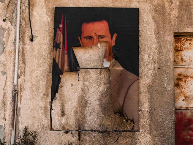 A defaced portrait of ousted president Bashar al-Assad is pictured in the town of Adra on the northeast outskirts of Damascus. Picture: AFP