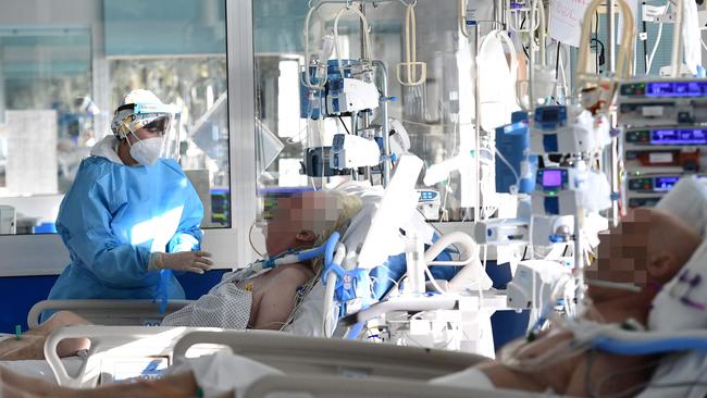 A medical staff member tends to a Covid-19 patient at the intensive care unit of Cremona hospital, in Cremona, northern Italy, on January 11, 2022. - Italy's Prime Minister Mario Draghi put the pressure back on the unvaccinated on January 10, 2022, calling them the cause of "most of the problems" in the country, which has been plagued by the spread of the Omicron variant. (Photo by Miguel MEDINA / AFP)