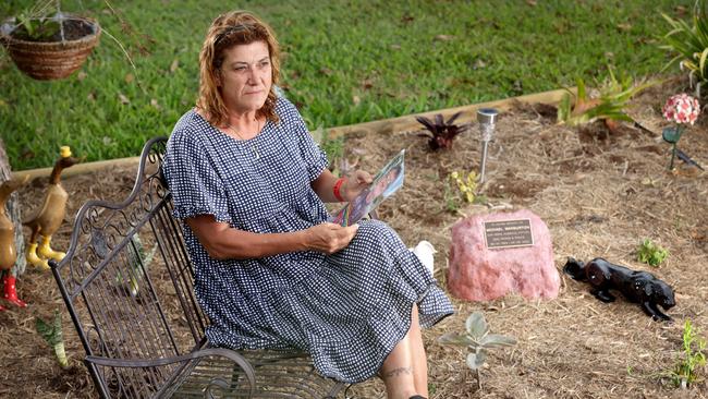 Anita Warburton, wife of Michael Warburton who was killed in a hit and run while riding a scooter in September last year sitting in a memorial garden with Michaels ashes interned in a rock. Picture: Steve Pohlner