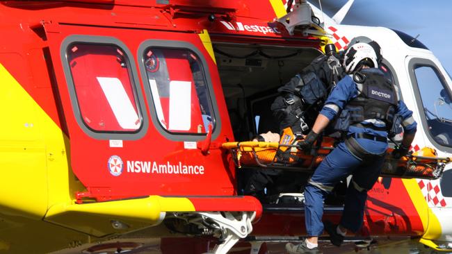 A critical car paramedic is winched up with a stretcher in the aircraft at an inter-agency exercise between Police Rescue and the Westpac Rescue Helicopter crews was held at Lismore on June 1, 2021. Photo: Alison Paterson