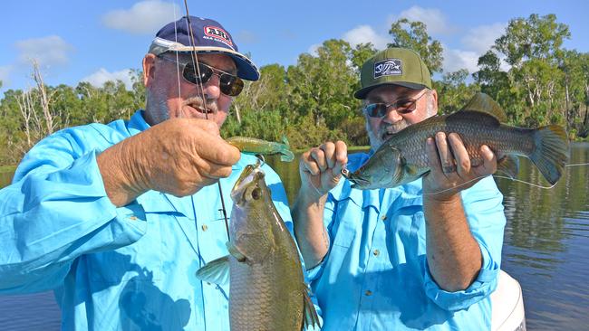 Ray Stenhouse (left) and Terry Atkinson display the two predominate size ranges of baby barra at Four Mile Hole: 45-50cm and 25-35cm.