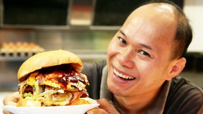 Eric Phu Soksan with his Wambie Whopper burger at Wamberal. Picture: Peter Clark