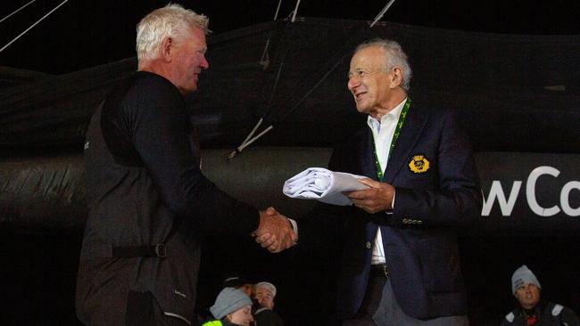 Vice Commodore of the Cruising Yacht Club of Australia David Jacobs presents the line honours flag in the 2024 Sydney to Hobart to sailing master of Law connect, Tony Mutter. Picture: Linda Higginson