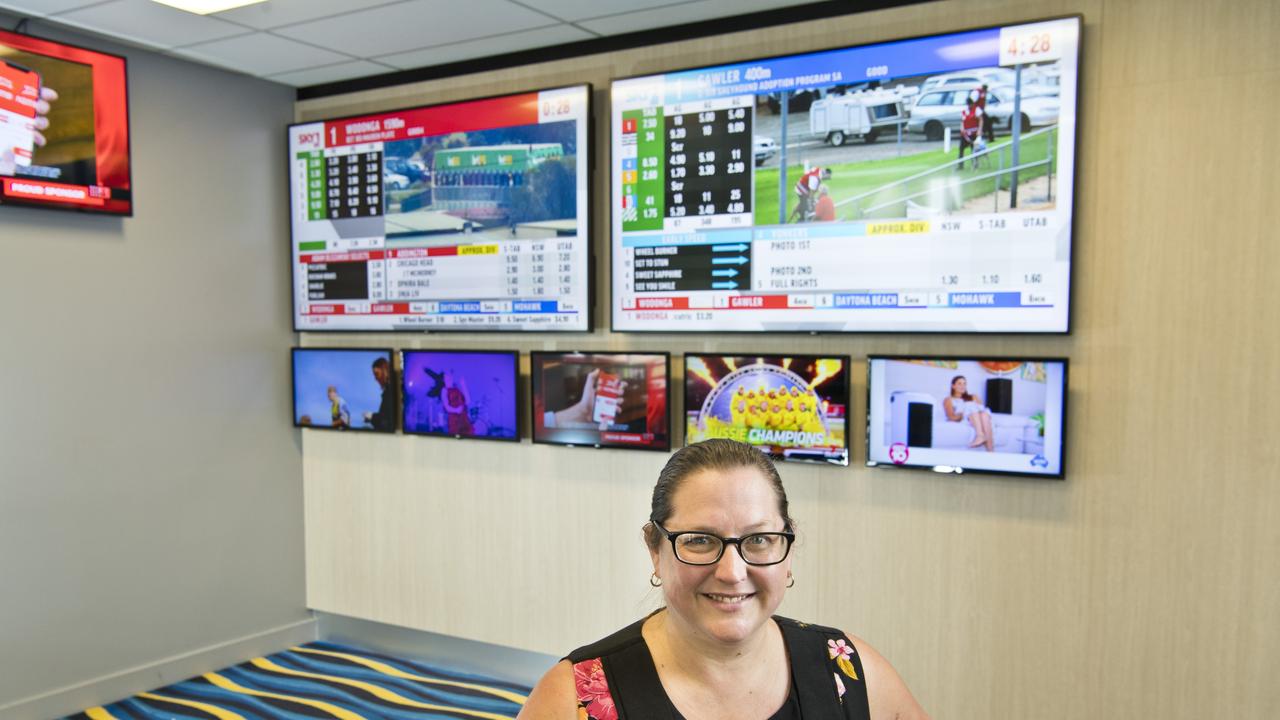 Toowoomba Turf Club chief executive officer Lizzy King underneath new television screens in the Clifford Park main bar area. Picture: Kevin Farmer