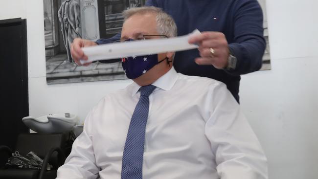 Prime Minister Scott Morrison gets a haircut at a barber shop during a visit to Malvern in Melbourne Eastern suburbs as the unofficial election campaigning intensifies. Picture: NCA NewsWire / David Crosling