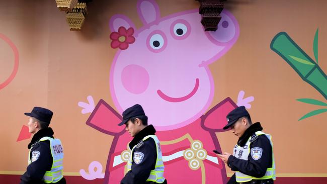 Police walk past a Peppa Pig figure on a wall outside the Yu Yuan gardens, a popular tourist spot Shanghai. Picture: AFP