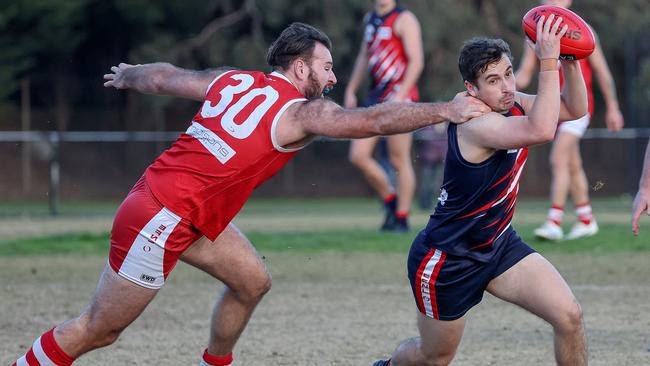 Ryan McNamara of Waverley Blues evades the tackle from Taylor Hayton of Warrandyte. Picture: George Salpigtidis