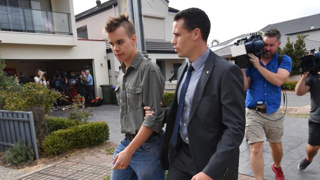 A protester is led away during a South Australian Premier Jay Weatherill press conference at Henley Beach, Adelaide, Friday, March 16, 2018. The press conference was held at the same location as where a year ago Mr Weatherill argued with Federal Energy Minister Josh Frydenberg as he was launching a federally-funded battery storage scheme. (AAP Image/David Mariuz) NO ARCHIVING