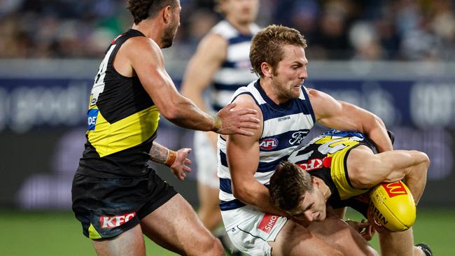 MELBOURNE, AUSTRALIA - JUNE 01: Thomson Dow of the Tigers is tackled by Tom Atkins of the Cats during the 2024 AFL Round 12 match between the Geelong Cats and the Richmond Tigers at GMHBA Stadium on June 01, 2024 in Melbourne, Australia. (Photo by Dylan Burns/AFL Photos via Getty Images)