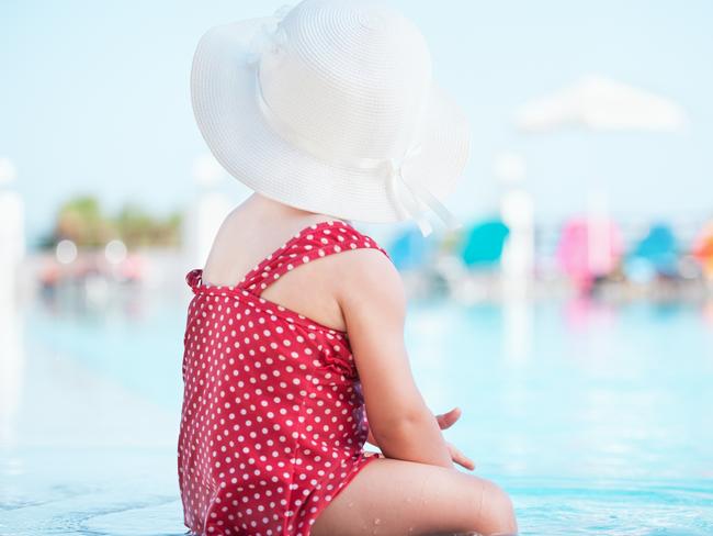 Cute toddler enjoying water in swimming pool