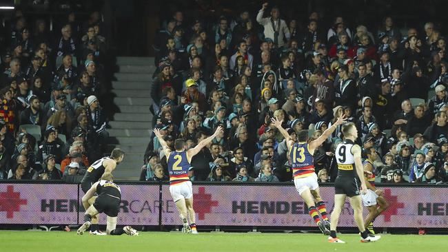 Brad Crouch and Taylor Walker run towards Eddie Betts after he kicked the last goal. Picture: Sarah Reed