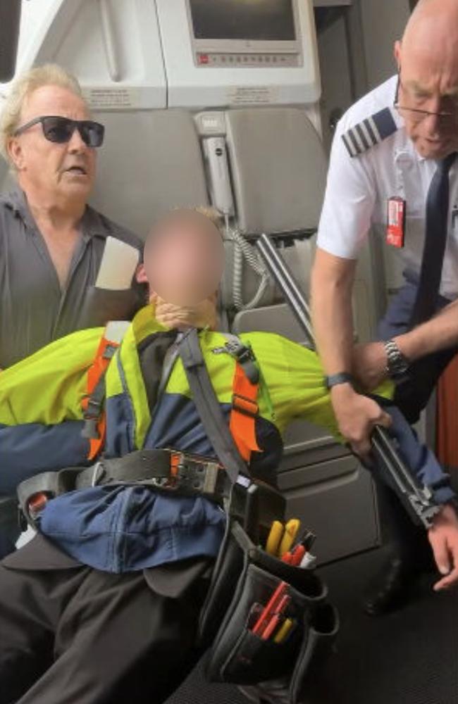 A teen was restrained by passenger Barry Clark (left) and a Jetstar crew member. Picture 9News