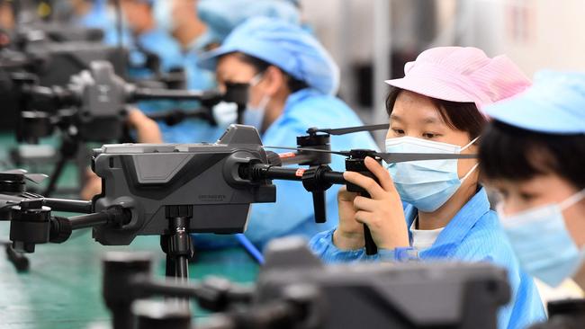 This photo taken on April 13, 2023 shows workers producing drones at a factory in Wuhan, in China's central Hubei province. (Photo by AFP) / China OUT