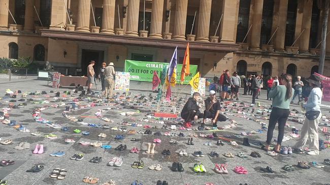 Hundreds of shoes arranged in a circle at the Extinction Rebellion protest at King George Square.