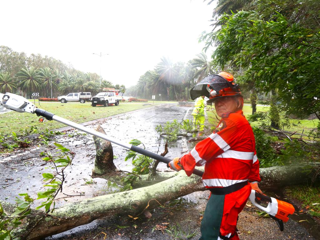 SES volunteer George Dellicompagni clears a fallen tree branch from Port Douglas Rd. Picture: Peter Carruthers