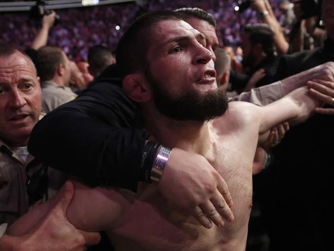 Khabib Nurmagomedov is held back outside of the cage after fighting Conor McGregor. Picture: AP Photo