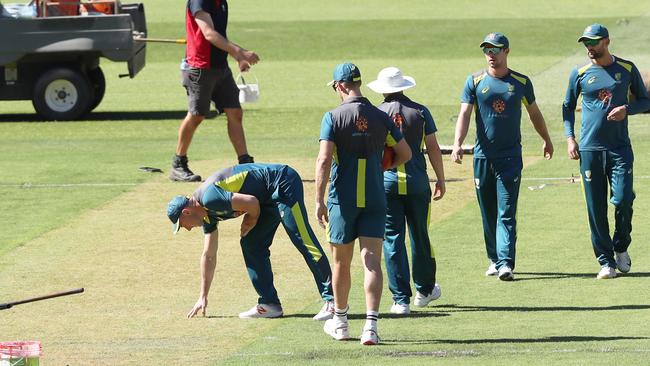 Australian Players inspect the pitch at the Melbourne Cricket Ground.