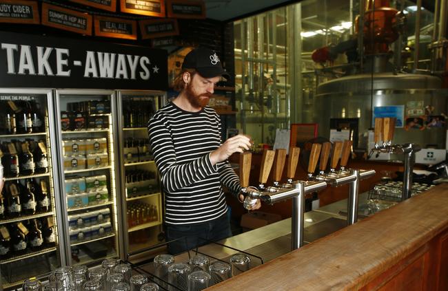 Marketing manager Andy Miller pulls a beer in the bar room of their brewery. Picture: John Appleyard