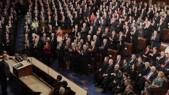 Republican Congress members stand and applaud as Democratic members sit. Picture: AP
