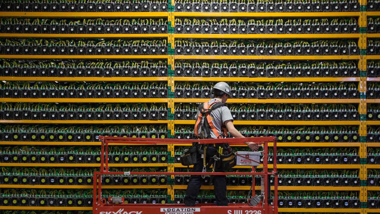 A technician inspects the backside of bitcoin mining at Bitfarms in Quebec, Canada in 2018. Picture: Lars Hagberg/AFP