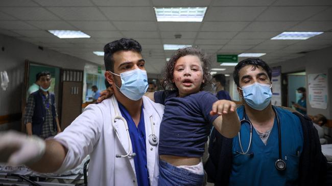 Palestinian doctors with a wounded girl at Al-Shifa Hospital in Gaza City on Sunday. Picture: AFP