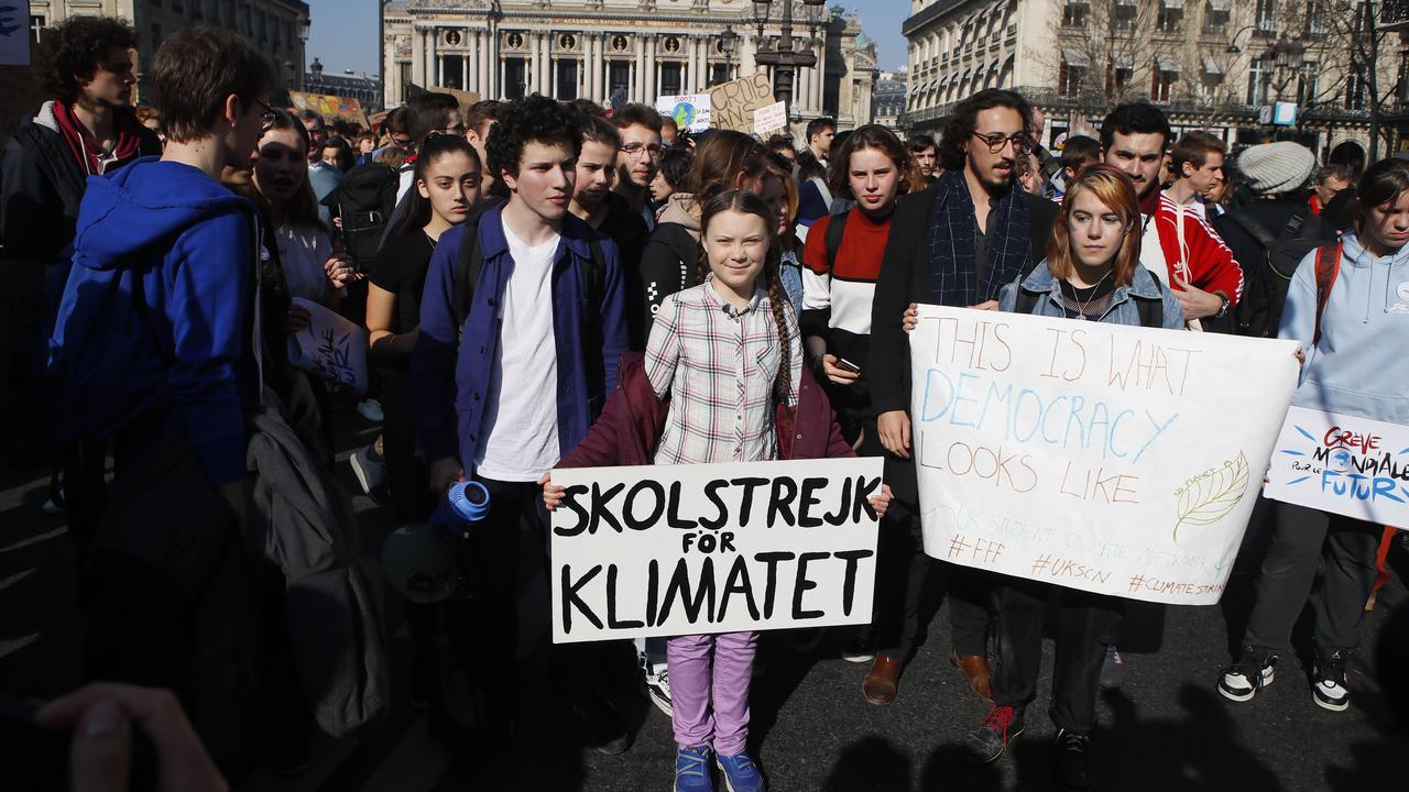 Swedish teenager Greta Thunberg, centre, leads a march of thousands of French students through Paris, France, to draw more attention to fighting climate change. Her sign reads: "school strike for climate". Picture: AP