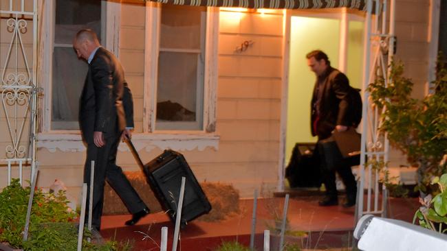 AFP officers leave the Brunswick house. Picture: Jay Town